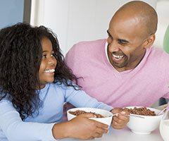 Father and daughter eating cereal