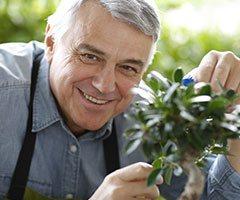 Man smiling holding plant